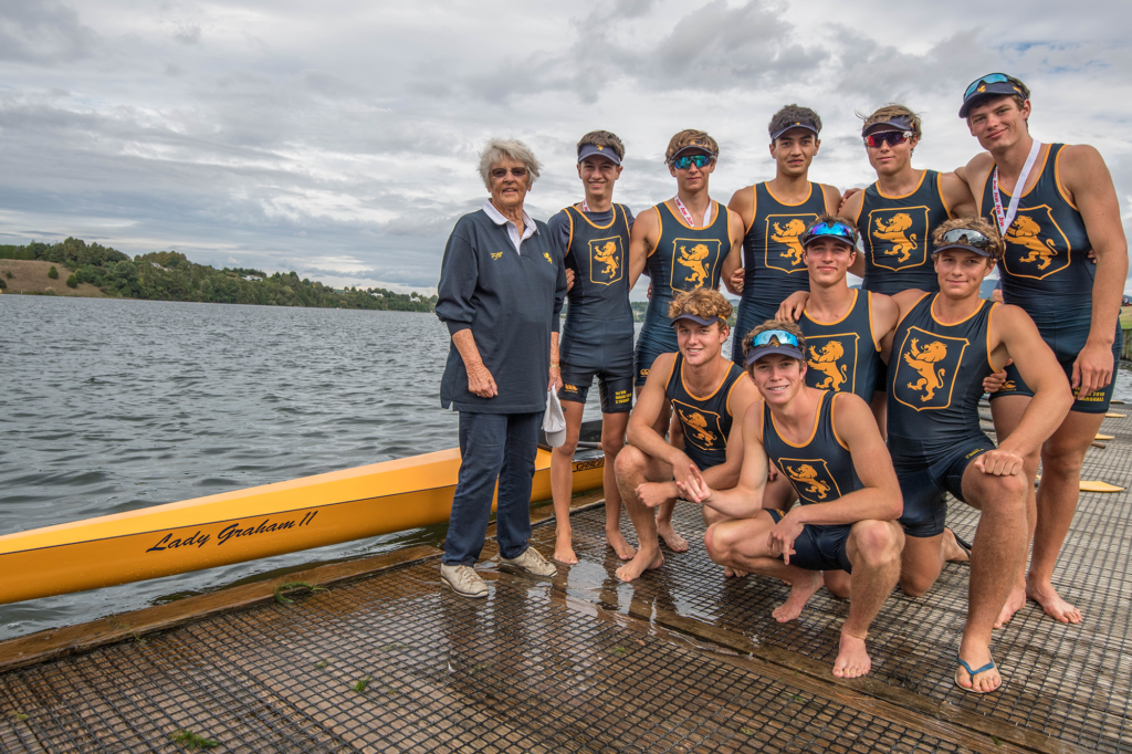 The 2019 Under 18 Eight crew with Shiela, Lady Graham and the skiff named in her honour