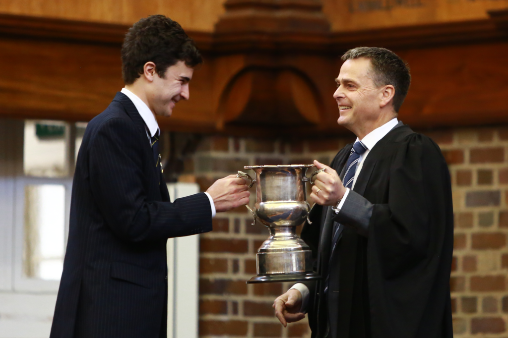 Isaac Mellis-Glynn receives the Debating trophy from Headmaster Mr Tim O'Connor